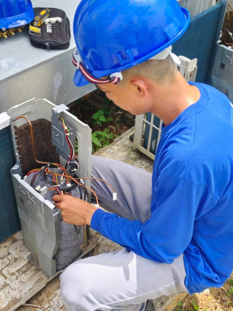 Technician servicing an outdoor condenser unit